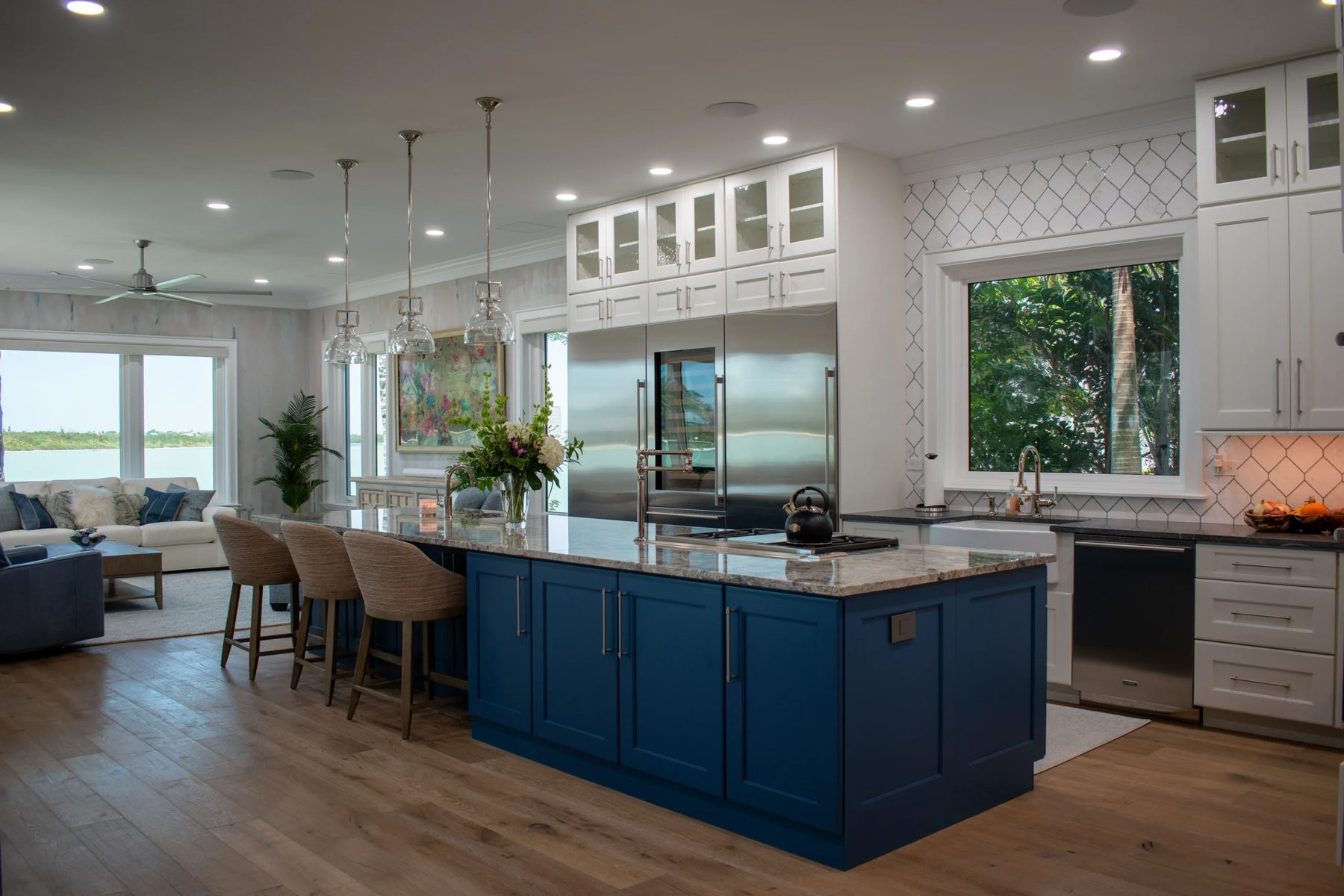 Remodeled waterfront kitchen in Sarasota with a blue island and white cabinetry